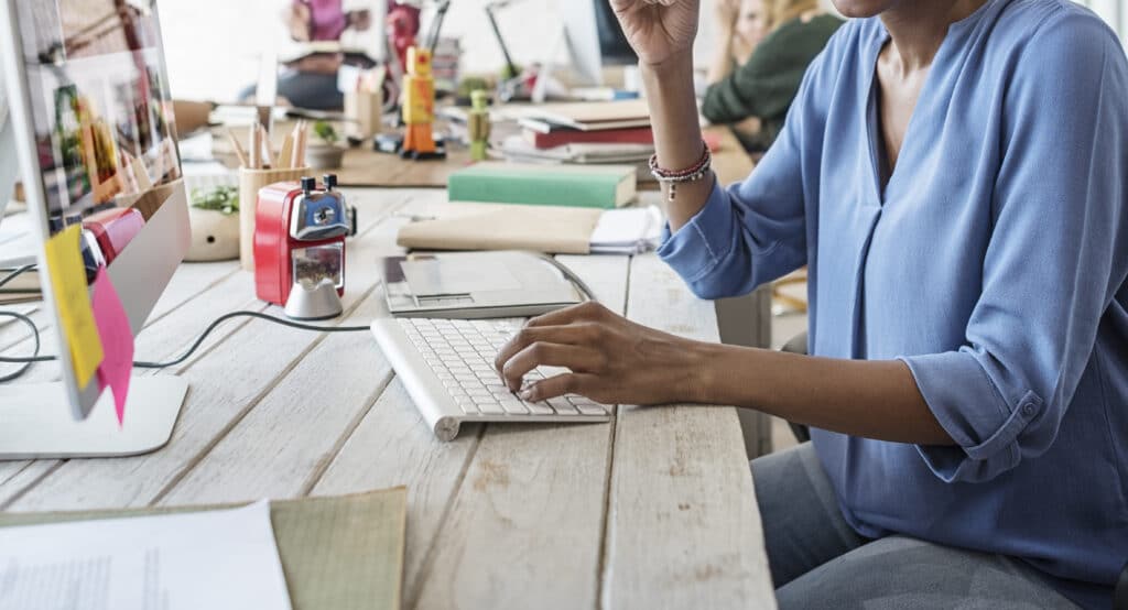 Employee Sitting at Desk Using Employee Platform for Work Communication