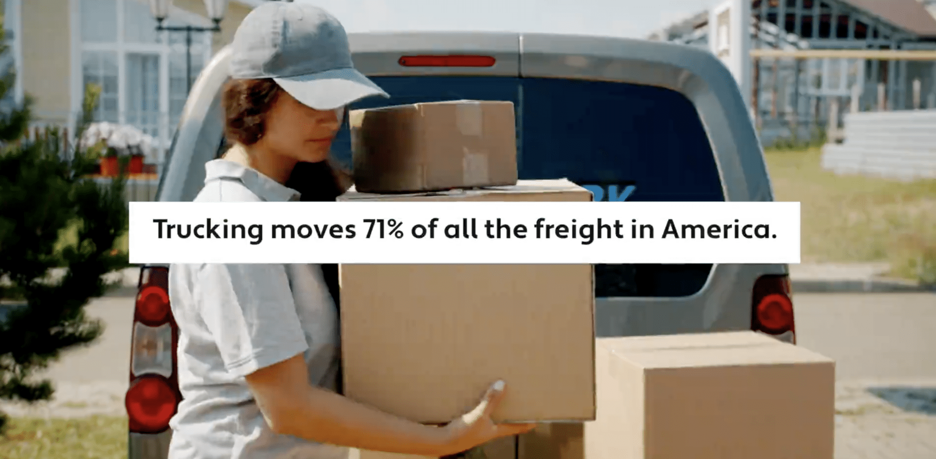 trucking-stat woman carrying boxes with a trunk open in the background