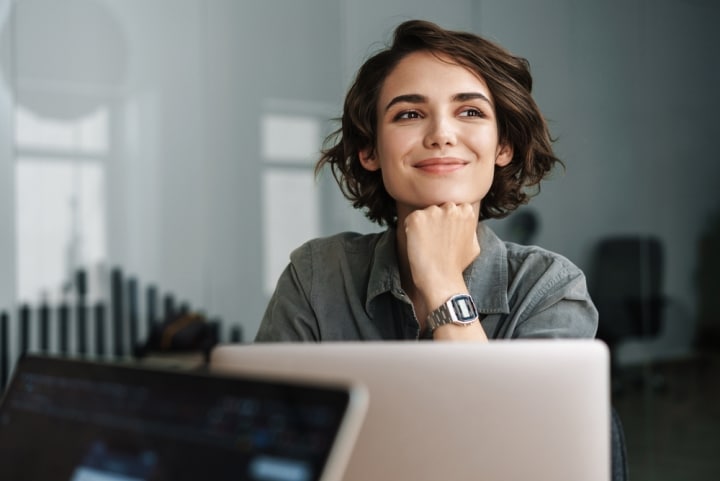 Happy, engaged employee smiling over laptop - iTacit