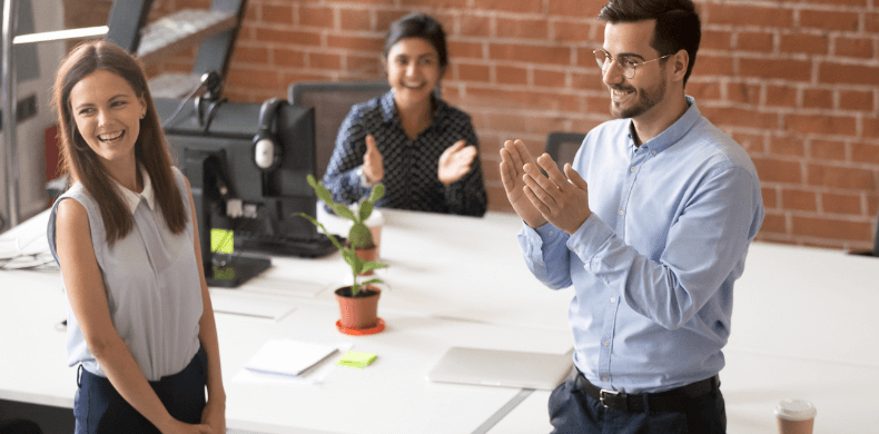 Employees in a board room being commended by the boss