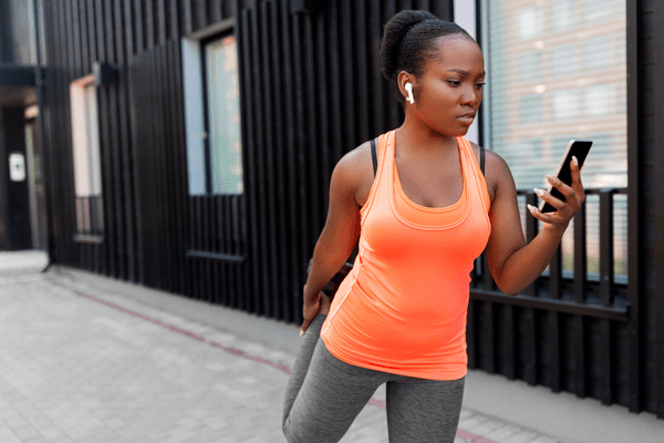 Woman watching training video while stretching before a workout