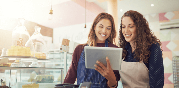Two employees smiling at an iPad